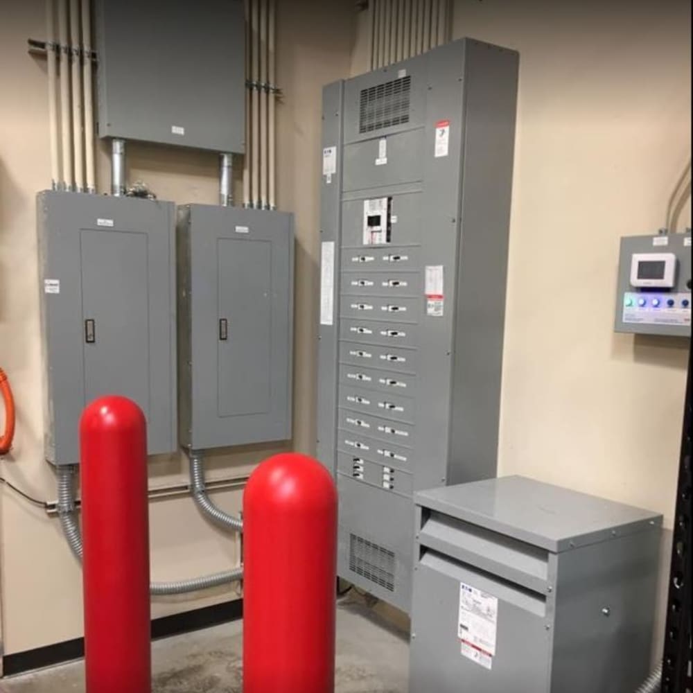 A room with many electrical boxes and two red fire hydrants.