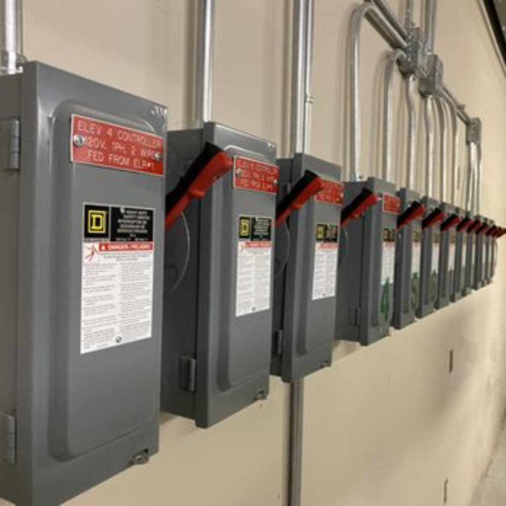 A row of electrical boxes hanging on the side of a wall.