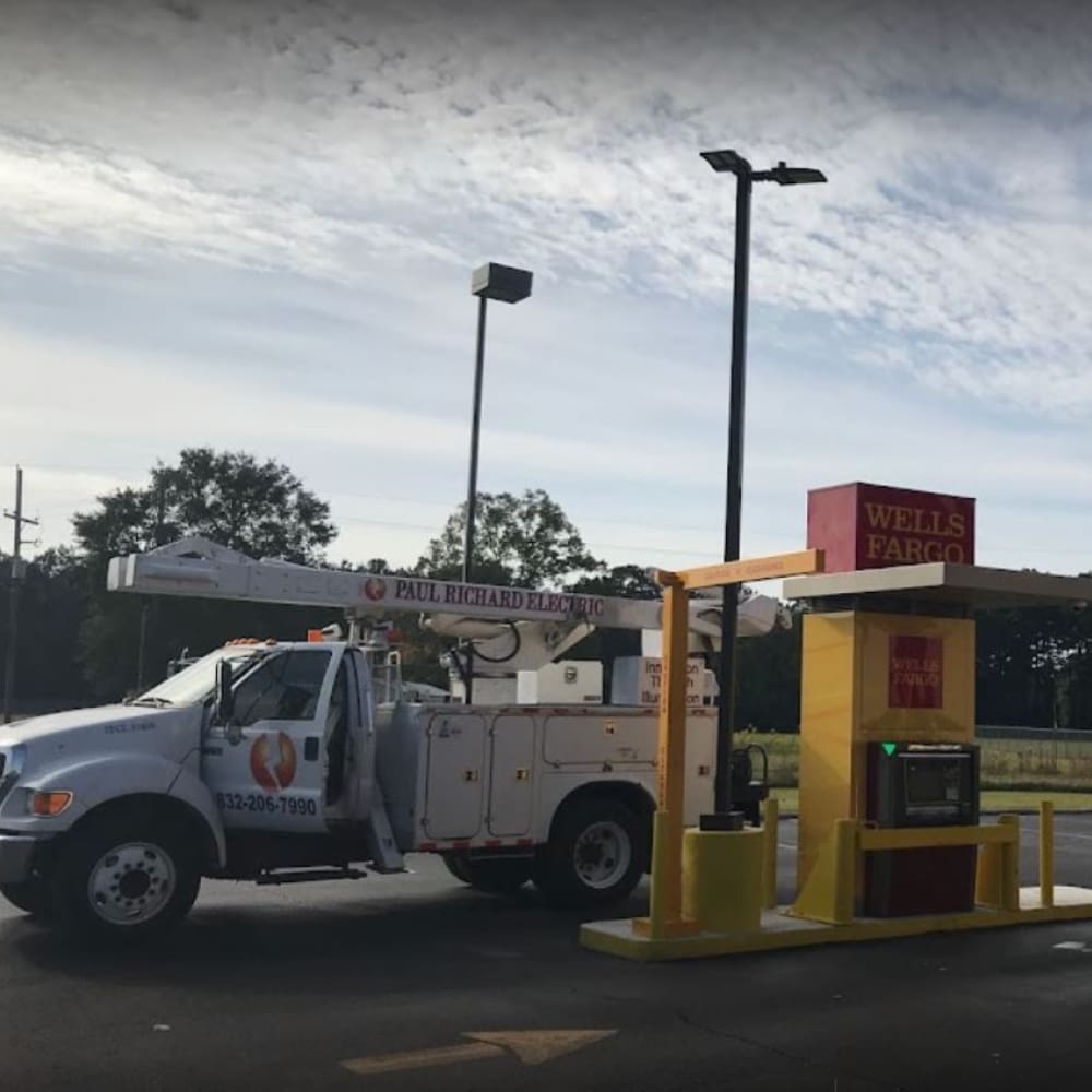 A white truck parked in front of a yellow and red building.