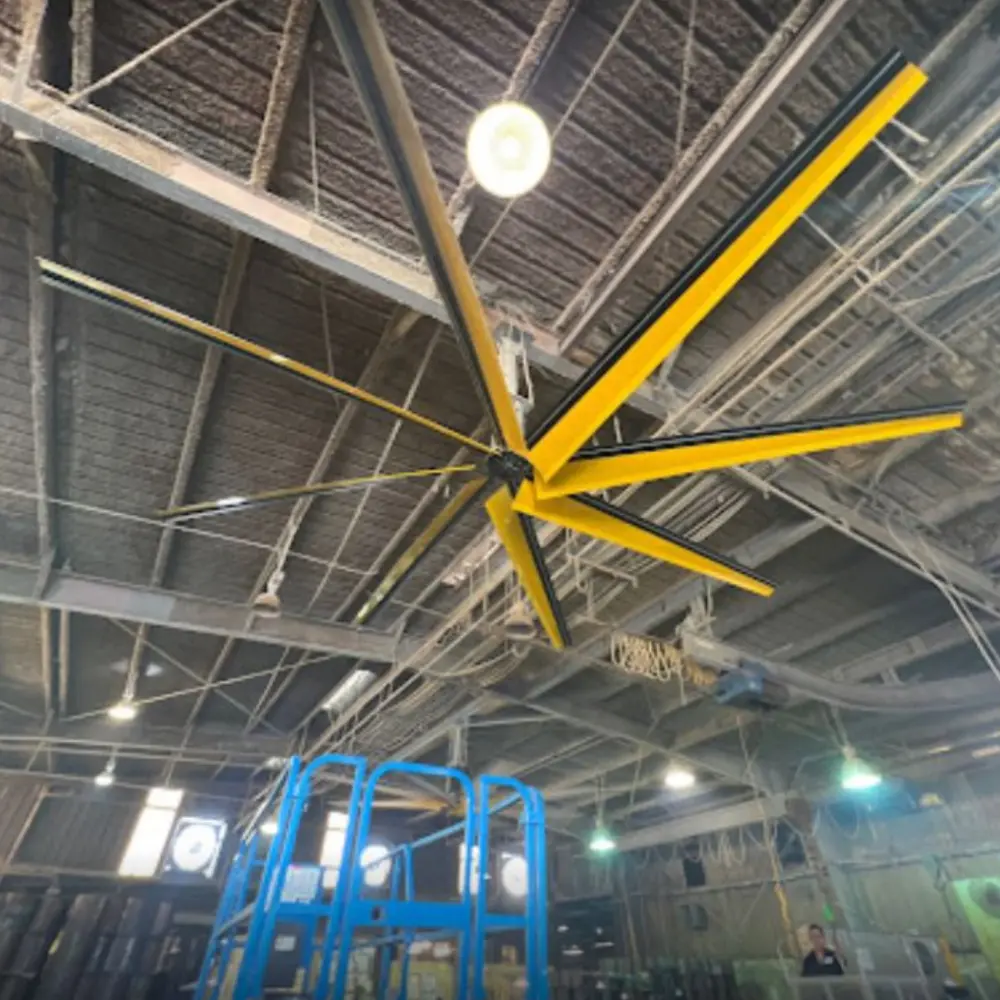 A large yellow ceiling fan in an industrial building.