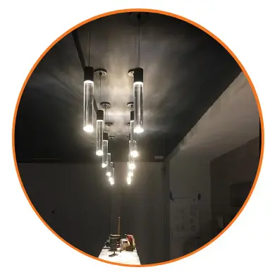 A round mirror with lights hanging from the ceiling.